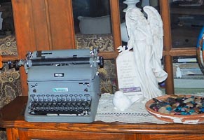 Old- fashioned manual Royal typewriter next to angel statue.
